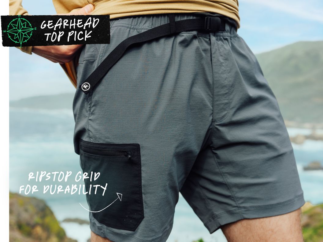 a closeup of shorts a man is wearing near the ocean. Text overlay reads: gearhead top pick, ripstop grid for durability.